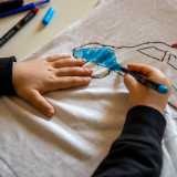 Gli alunni, che non indossano il grembiule tradizionale ma sono liberi di portare ci� che preferiscono, sono impegnati in un vero e proprio processo creativo: sono infatti intenti a disegnare e dipingere dei �manufatti� per la festa del pap�